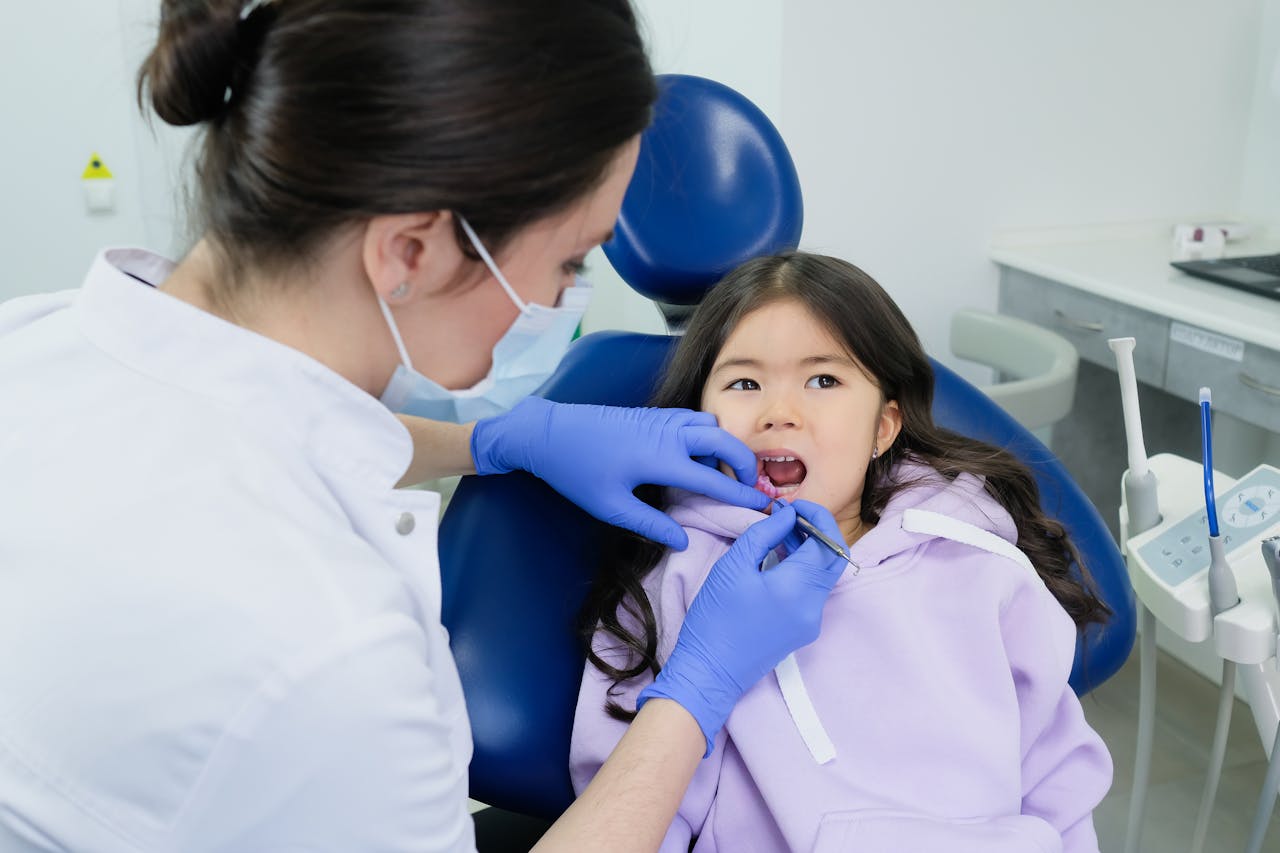 Child attending preventive dental check-up with dentist examining healthy teeth